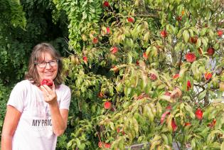 Claudia mit frisch gepflückten Pfirsich