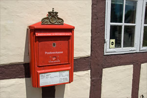 Roter Postbriefkasten an Fachwerkhaus