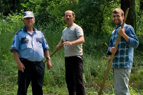 Drei albanische Arbeiter, die die Anlage pflegen, schauen freundlich in die Kamera.