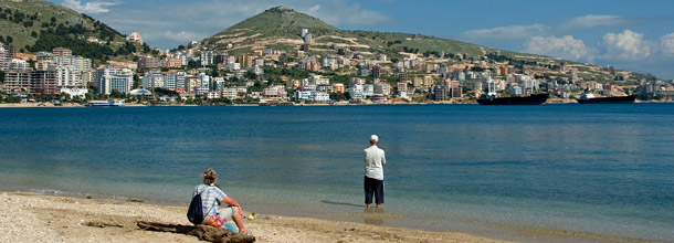 Strand an weitläufiger Bucht mit Blick auf die Häuser der Stadt