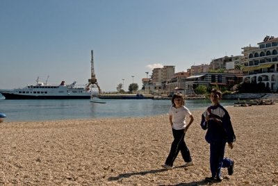 Zwei Kinder spazieren am Strand vor der Kamera auf und ab