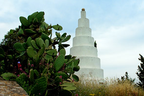 Turm, der wie aus unterschiedlich großen aufgeschichteten Mühlsteinen ausschaut