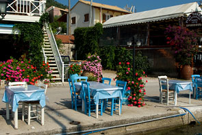 Hellblaue Stühle und Tische eines Restaurants am Kai