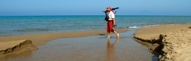 Thomas mit Kamera und Stativ läuft am Strand