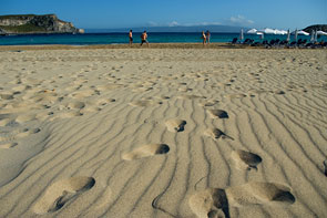 Breiter Sandstrand mit Badegästen und dem Meer im Hintergrund