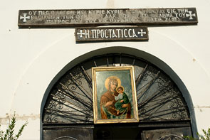 Geschmiedete Eisentür mit einem Ikonen-Bild über dem Rundbogen. Auf dem Bild ist Maria mit dem Kind.