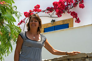 Claudia vor weißer Hauswand mit roten Bougainvillas